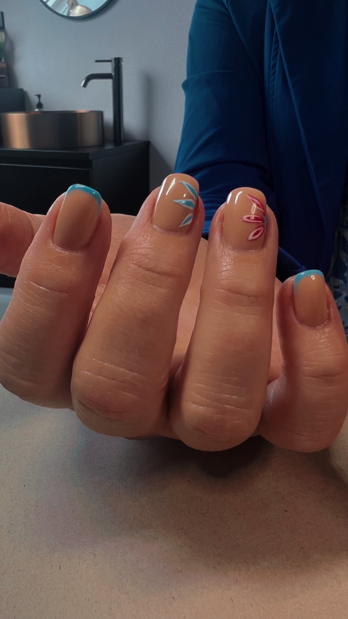 Bruine nagels met fijne nail art en blauwe tips, in de salon