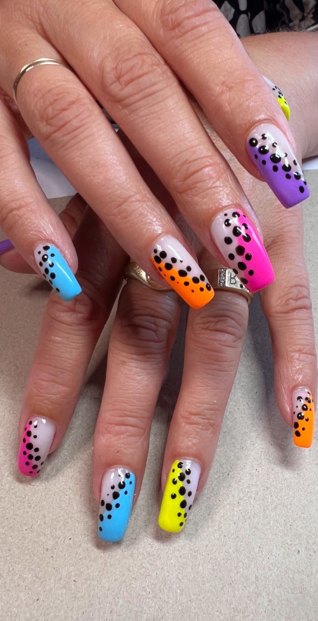 Lange nagels in neonkleuren met zwarte stippen